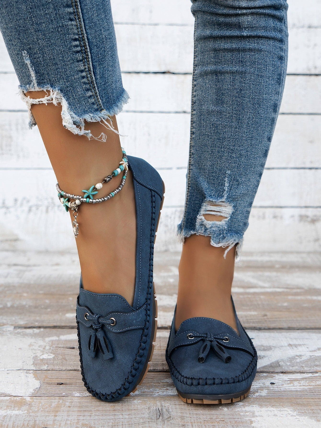 Women's blue tassel loafers front view on foot