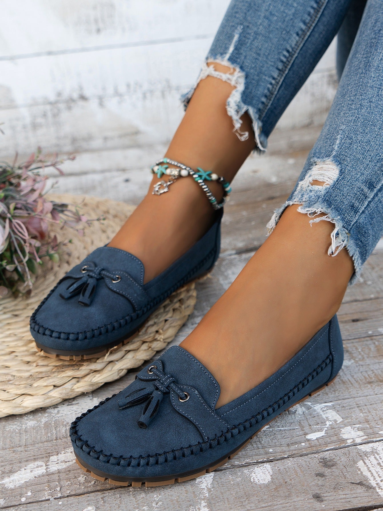 Women's blue tassel loafers side view on foot
