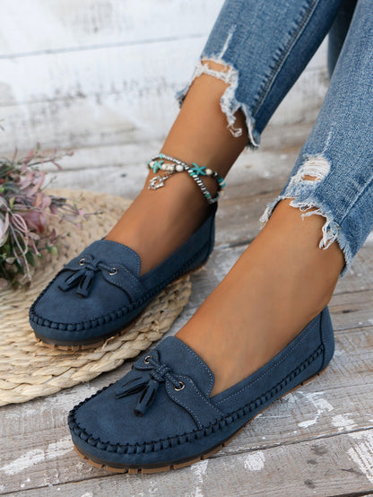 Women's blue tassel loafers side view on foot