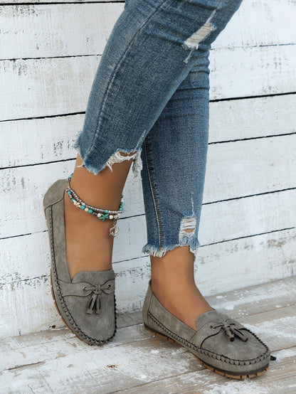 Women's gray tassel loafers front view on foot