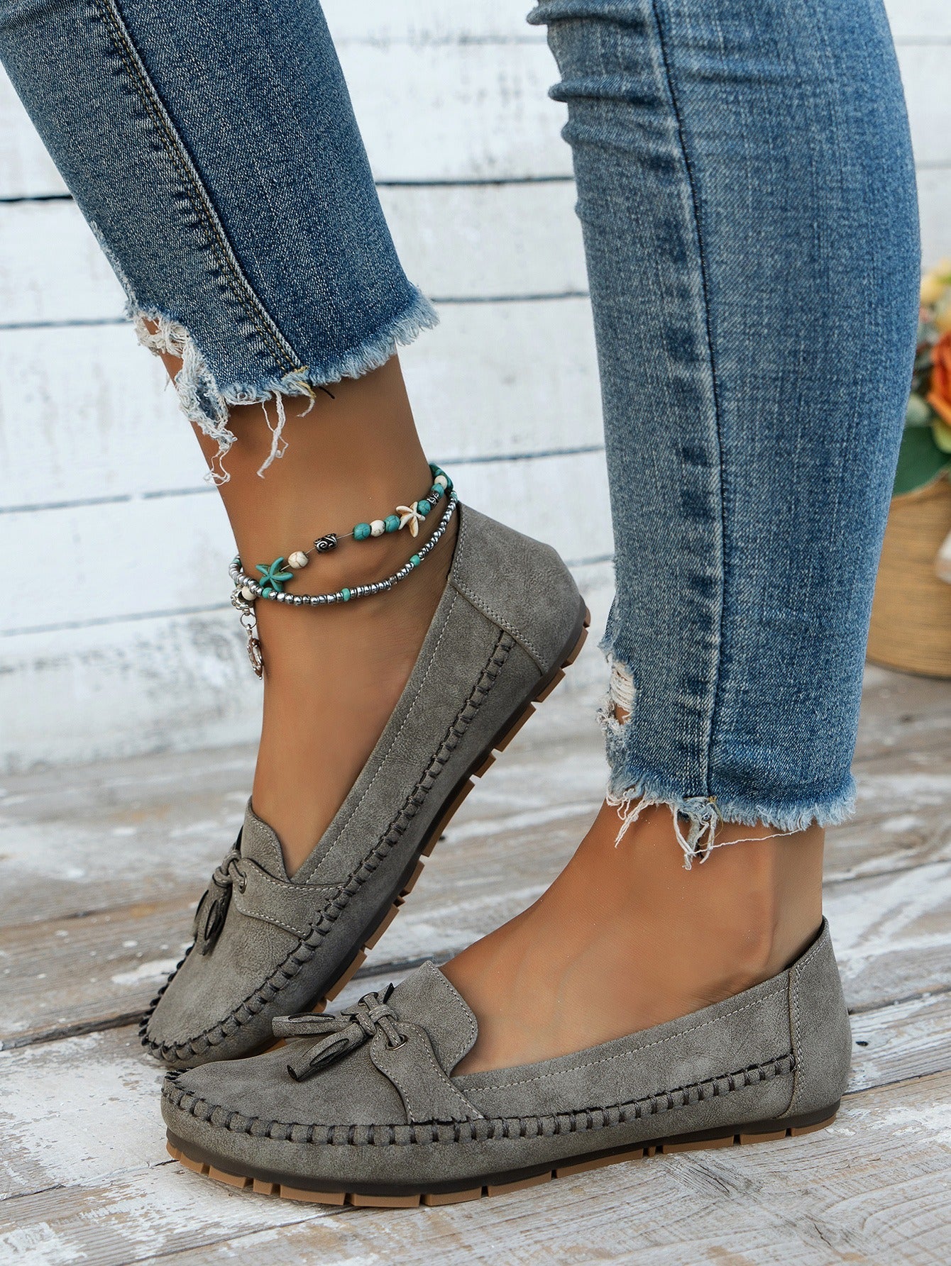 Women's gray tassel loafers side view on foot