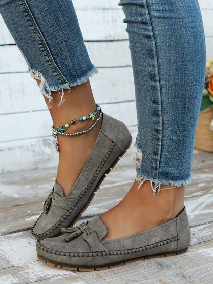 Women's gray tassel loafers side view on foot