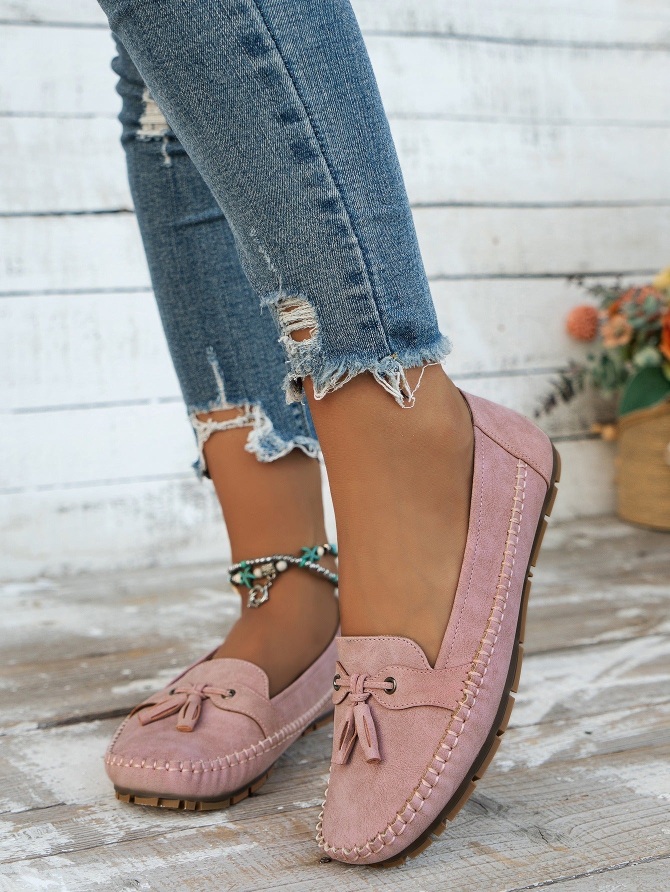 Women's pink tassel loafers side view on foot