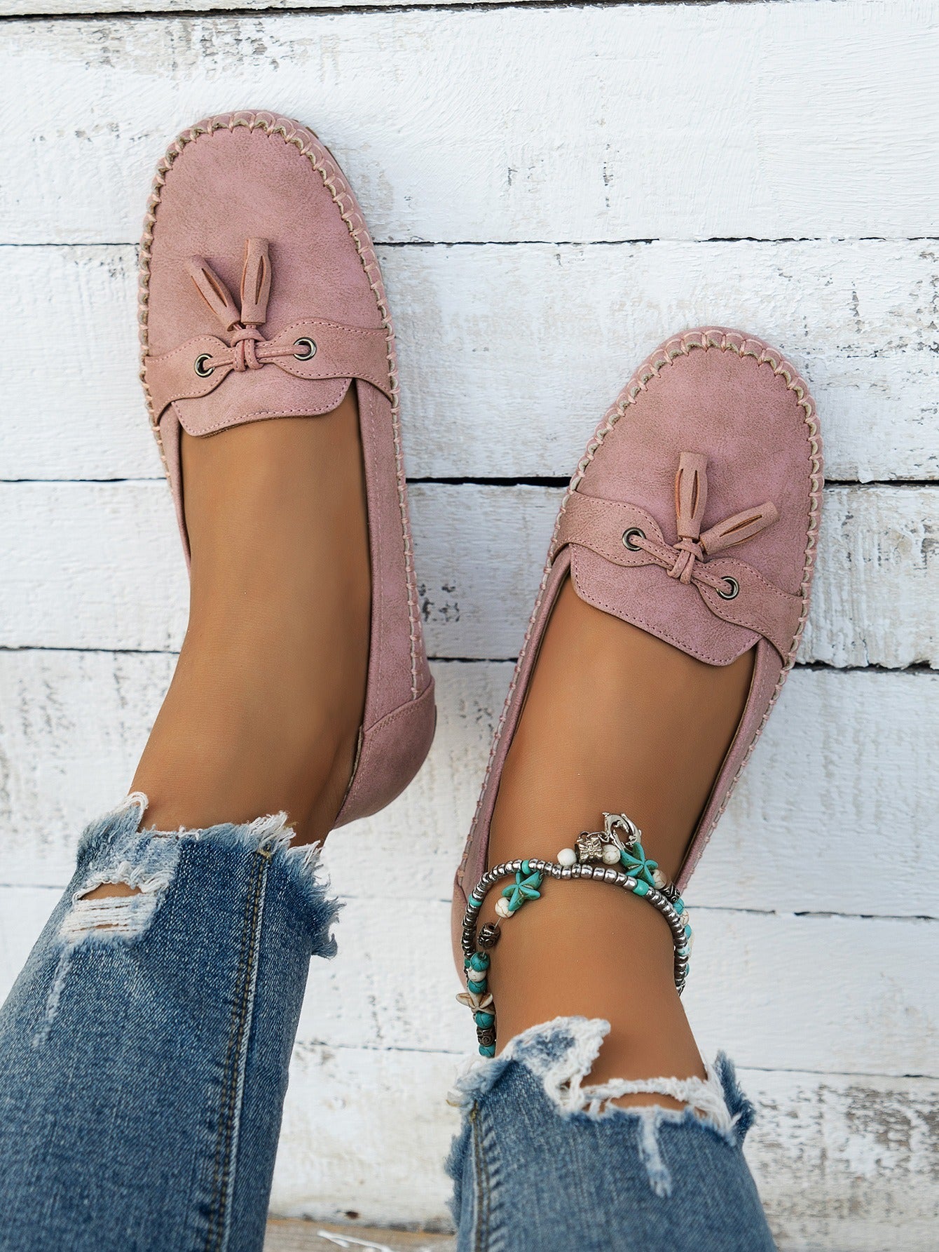 Women's pink tassel loafers top view on foot